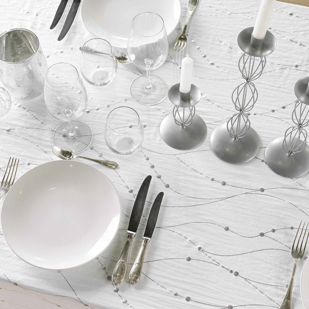 Nærbillede af opdækning med Firmament Metallic hvid dug med bølgende sølvprint