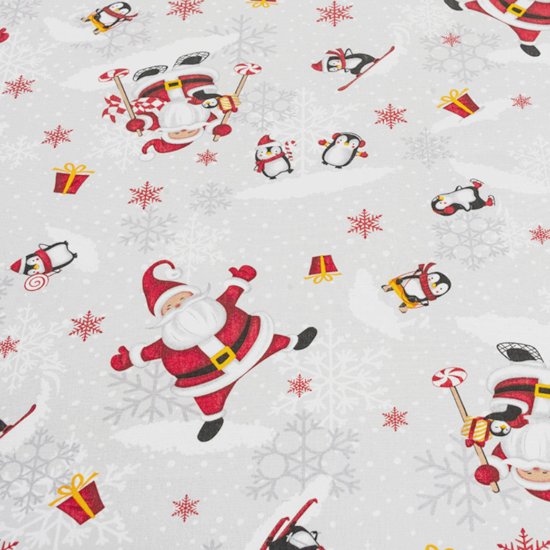 Nærbillede af Julefest på Sydpolen juledug med julemænd og pingviner i sneen.