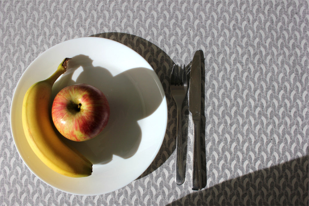 Munch Grey akryldug med elegante linjer og kurver på et festligt bord, 180 cm