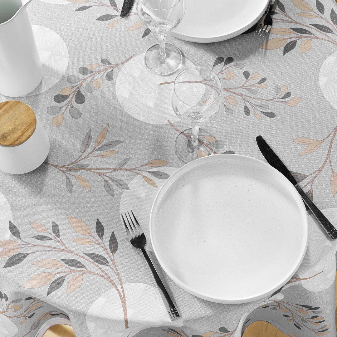 Nærbillede af grå dug med bladprint og spisebestik