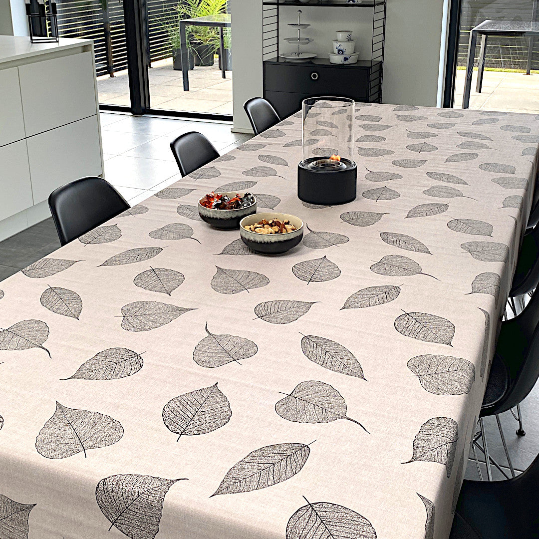 Voksdug med detaljerede sorte blade og hørlook på bord